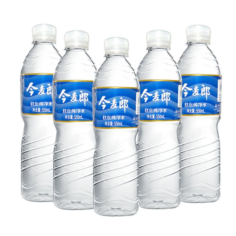Rotary hot melt labeling machine on a mineral water bottling line