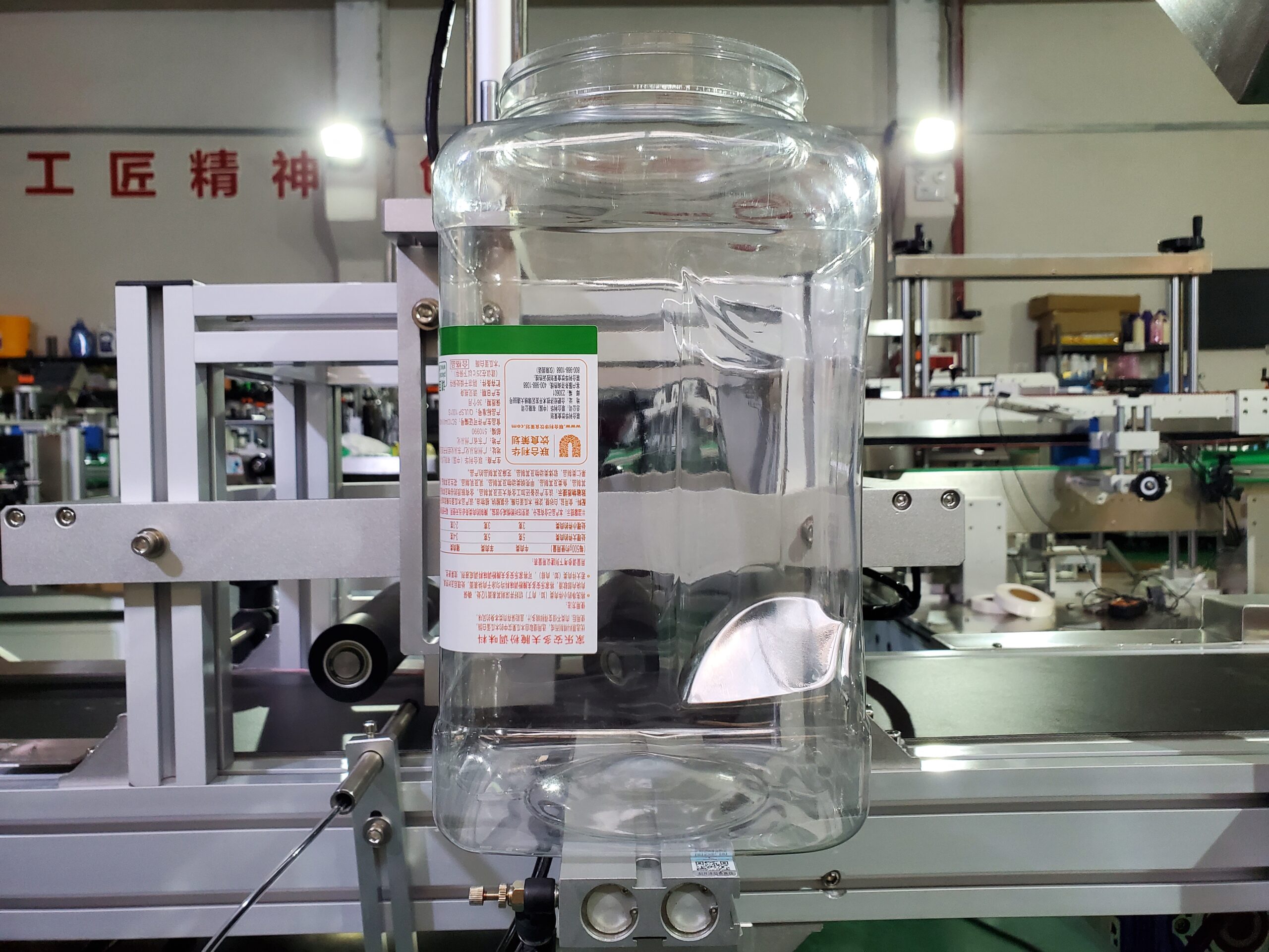MT-805 semi-automatic wrap-around labeling machine labeling a round bottle on a workbench
