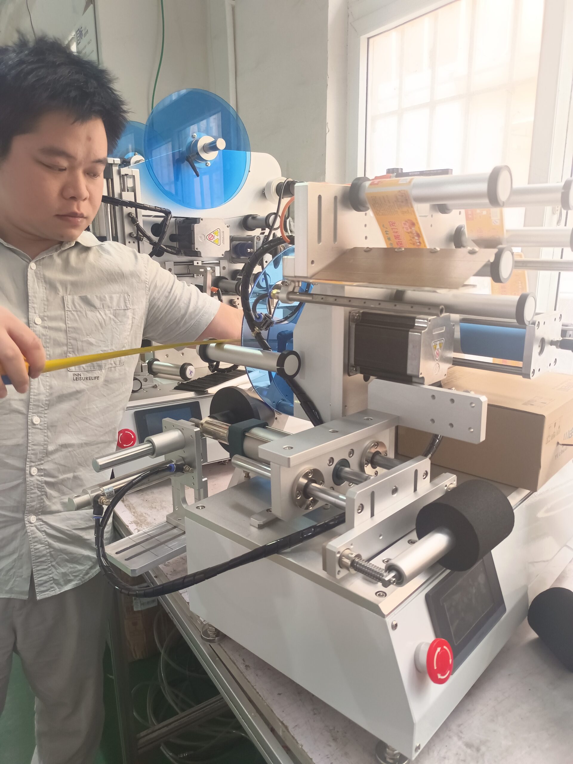 MT-805 semi-automatic wrap-around labeling machine applying a label to a round bottle
